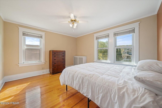 bedroom featuring light hardwood / wood-style flooring, ceiling fan, and crown molding