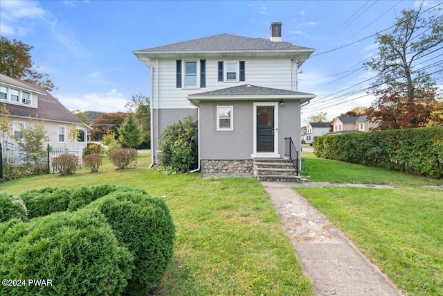 rear view of house featuring a yard