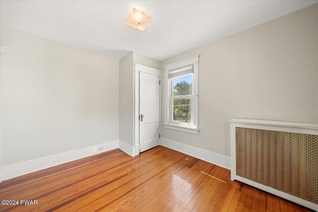 empty room featuring hardwood / wood-style floors and radiator