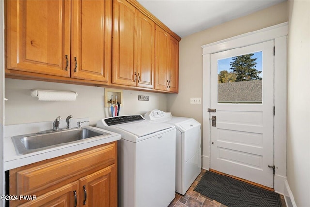 laundry area featuring washing machine and clothes dryer, sink, and cabinets