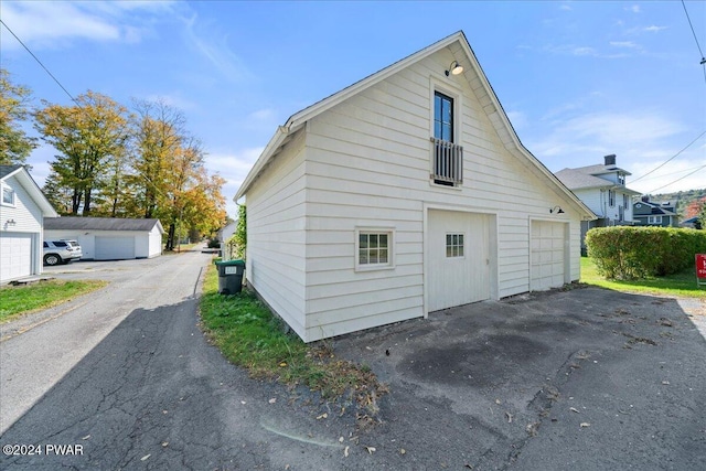 view of home's exterior with a garage and an outbuilding