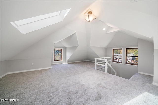 bonus room featuring vaulted ceiling with skylight and carpet flooring