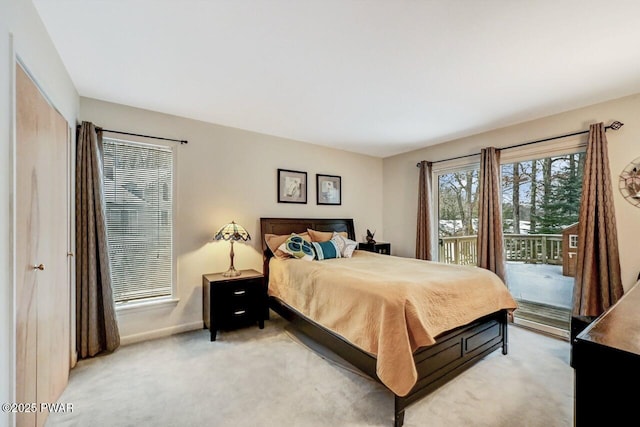 bedroom featuring light carpet and access to outside