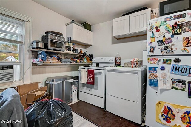 clothes washing area featuring light hardwood / wood-style floors, cabinets, separate washer and dryer, and cooling unit