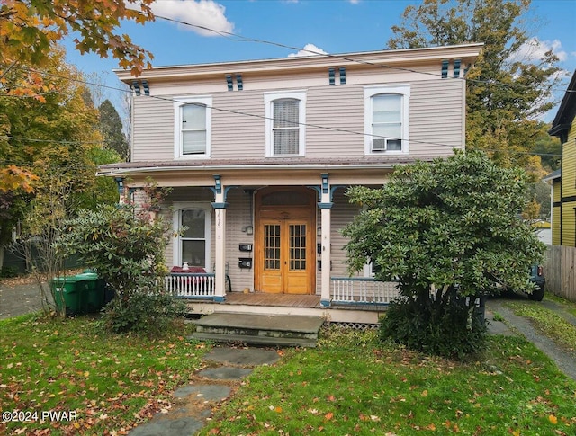 italianate-style house with a porch and a front yard