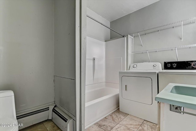 clothes washing area featuring washing machine and dryer and a baseboard heating unit