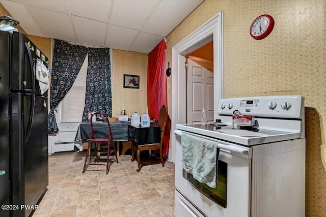 kitchen featuring a paneled ceiling, black refrigerator, and white electric stove