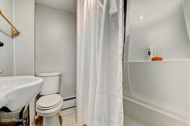 bathroom featuring tile patterned floors, shower / bath combination with curtain, toilet, and a baseboard radiator