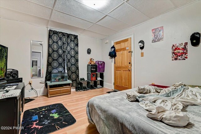 bedroom featuring a drop ceiling and hardwood / wood-style floors