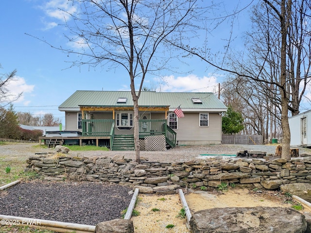back of property featuring metal roof and fence