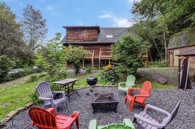 view of patio / terrace with a deck and an outdoor fire pit