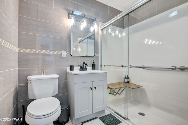 bathroom featuring walk in shower, vanity, tile walls, and toilet