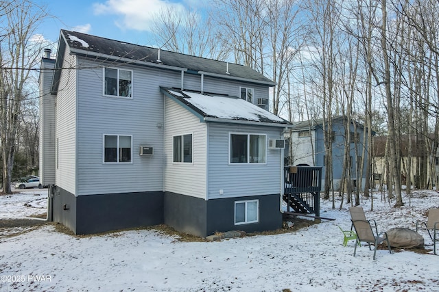 snow covered property featuring a wall unit AC