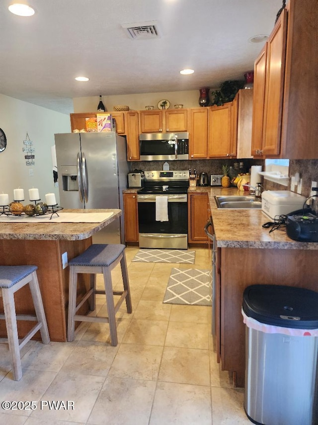 814 Clearview Dr, Long Pond, PA 18334 - kitchen featuring visible vents, decorative backsplash, a breakfast bar, a sink, and stainless steel appliances