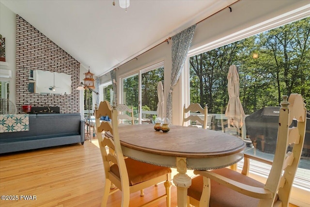 115 Washington Dr, Lords Valley, PA 18428 - dining room featuring wood finished floors, high vaulted ceiling, and brick wall