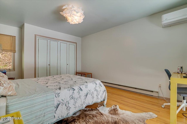 115 Washington Dr, Lords Valley, PA 18428 - bedroom featuring baseboard heating, an AC wall unit, wood finished floors, and a closet