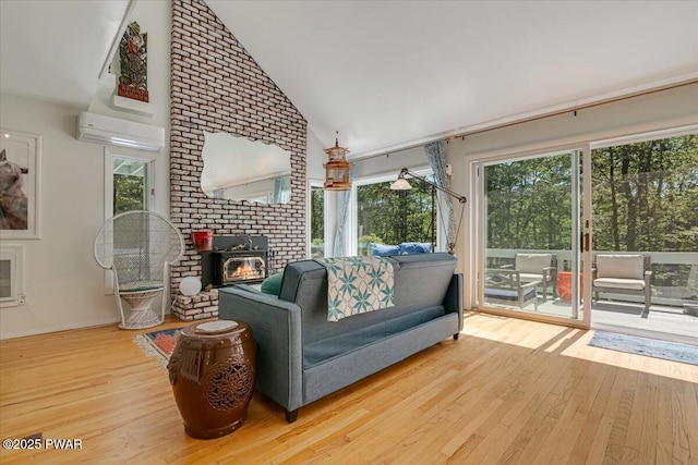 115 Washington Dr, Lords Valley, PA 18428 - living area featuring a wall mounted air conditioner, healthy amount of natural light, wood-type flooring, a wood stove, and high vaulted ceiling