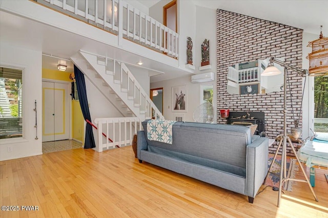 115 Washington Dr, Lords Valley, PA 18428 - living area with a wall mounted air conditioner, hardwood / wood-style floors, stairs, and high vaulted ceiling
