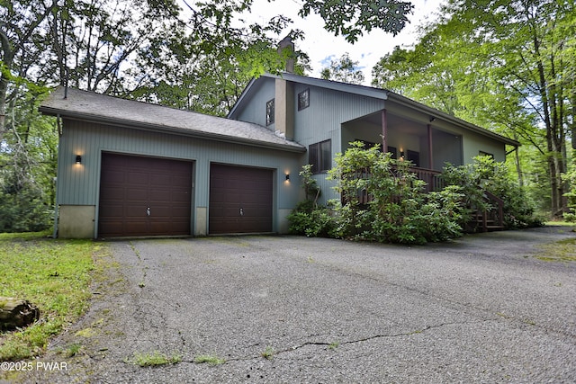 216 Canterbrook Dr, Lords Valley, PA 18328 - view of property exterior featuring driveway, an attached garage, and a chimney