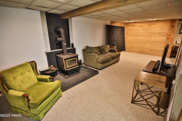 216 Canterbrook Dr, Lords Valley, PA 18328 - carpeted living area featuring a wood stove, a paneled ceiling, and wooden walls