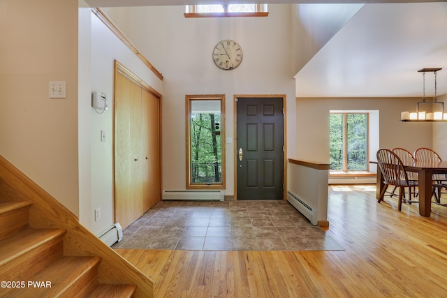 2766 Owego Tpke, Hawley, PA 18428 - foyer with a baseboard heating unit, baseboard heating, wood finished floors, stairs, and a towering ceiling