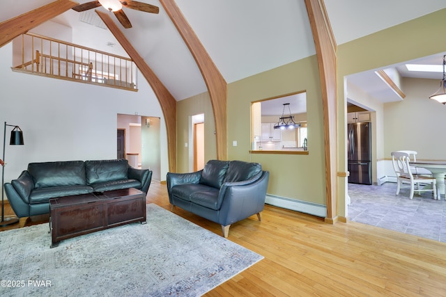 2766 Owego Tpke, Hawley, PA 18428 - living room featuring a baseboard heating unit, wood finished floors, a ceiling fan, high vaulted ceiling, and beamed ceiling