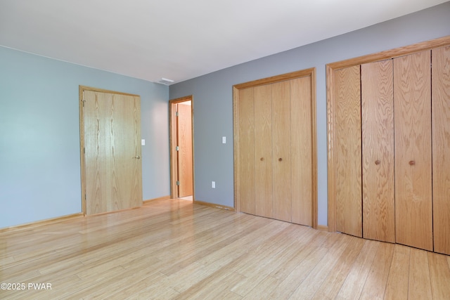 2766 Owego Tpke, Hawley, PA 18428 - unfurnished bedroom featuring two closets and wood finished floors