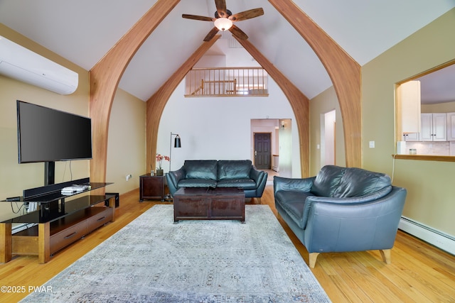 2766 Owego Tpke, Hawley, PA 18428 - living area with wood finished floors, an AC wall unit, ceiling fan, baseboard heating, and high vaulted ceiling