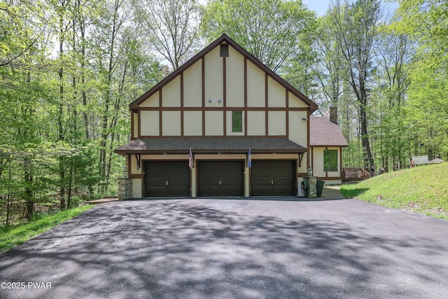 2766 Owego Tpke, Hawley, PA 18428 - view of front of home with asphalt driveway, a chimney, roof with shingles, an attached garage, and stucco siding