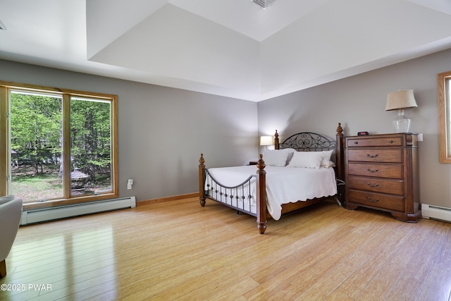 2766 Owego Tpke, Hawley, PA 18428 - bedroom with a baseboard heating unit, light wood-type flooring, multiple windows, and a raised ceiling