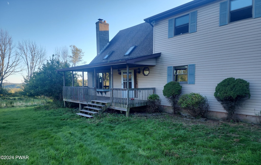 exterior space featuring covered porch and a yard