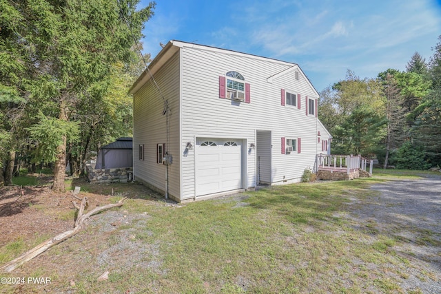 view of home's exterior with a wooden deck, a yard, and a garage