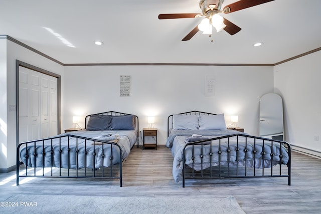 bedroom featuring hardwood / wood-style flooring, ceiling fan, ornamental molding, and a closet