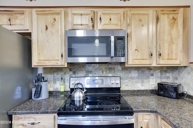 kitchen featuring tasteful backsplash, dark stone countertops, light brown cabinets, and stainless steel appliances