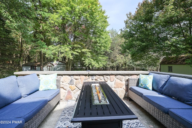 view of patio with an outdoor living space with a fire pit and a storage shed