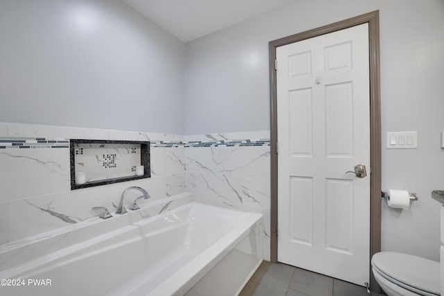 bathroom with tile patterned floors, a bath, and toilet