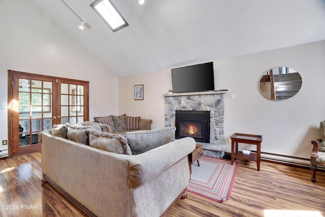 living room featuring a fireplace, a textured ceiling, hardwood / wood-style flooring, and high vaulted ceiling