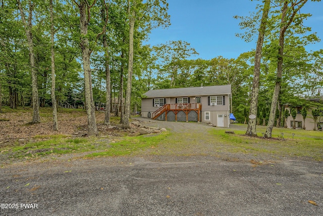 1011 Salem Pl, Lake Ariel, PA 18436 - view of front facade featuring stairs, dirt driveway, a garage, and a wooden deck