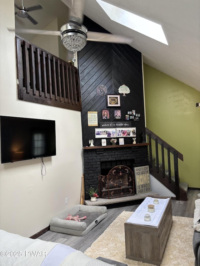 1267 Brookfield Rd, Lake Ariel, PA 18436 - living room with a ceiling fan, wood finished floors, a skylight, vaulted ceiling, and a brick fireplace