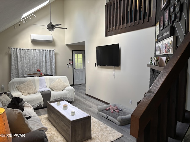 1267 Brookfield Rd, Lake Ariel, PA 18436 - living area with a wall unit AC, wood finished floors, ceiling fan, a high ceiling, and track lighting