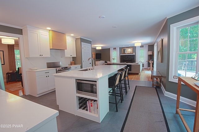 401 Log Tavern Rd, Milford, PA 18337 - kitchen with appliances with stainless steel finishes, premium range hood, open floor plan, white cabinets, and an island with sink
