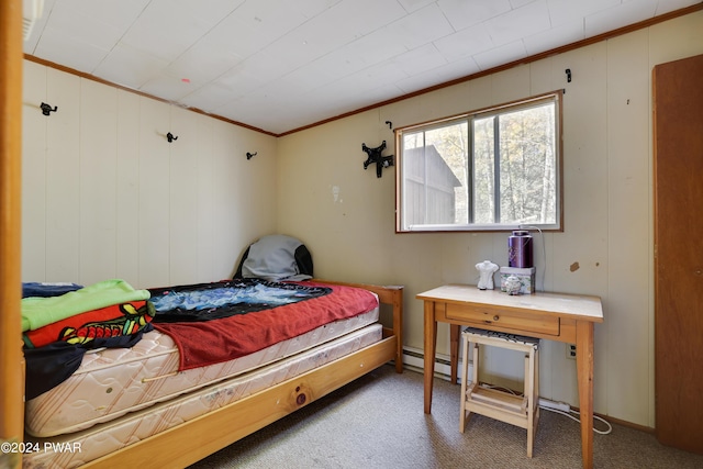 carpeted bedroom with crown molding and a baseboard heating unit