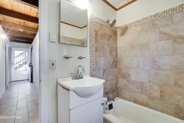 bathroom featuring vanity, beam ceiling, and tiled shower / bath