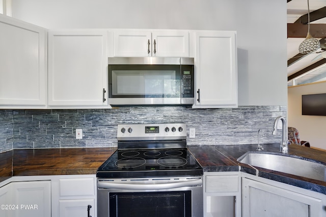 kitchen featuring decorative backsplash, white cabinetry, sink, and appliances with stainless steel finishes