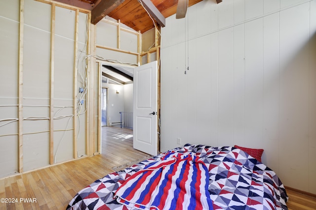 bedroom with lofted ceiling with beams, wood ceiling, and light hardwood / wood-style flooring