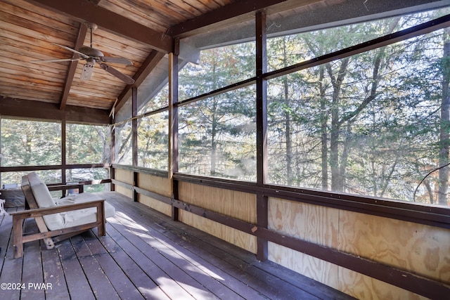 unfurnished sunroom featuring vaulted ceiling with beams, ceiling fan, and wooden ceiling