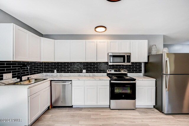 1412 Woodview Ter # 56, Lake Ariel, PA 18436 - kitchen featuring appliances with stainless steel finishes, a sink, backsplash, and white cabinets