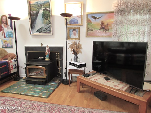 sitting room with hardwood / wood-style floors and a wood stove