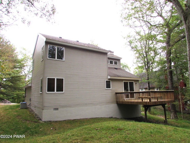 rear view of property featuring central AC unit, a deck, and a lawn