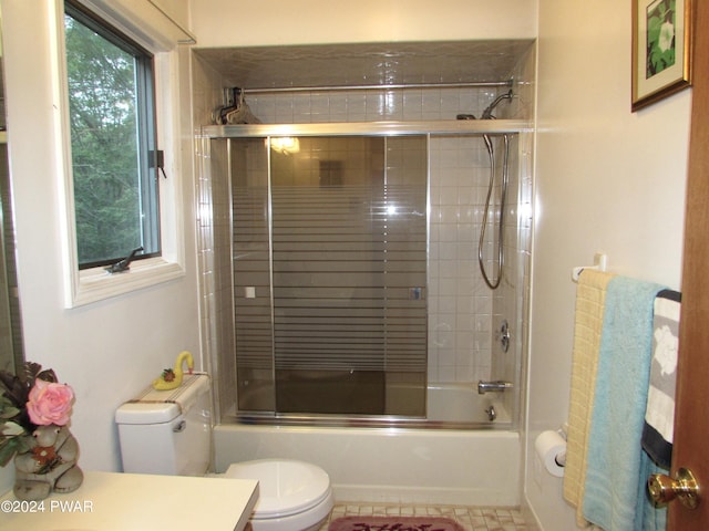 full bathroom with plenty of natural light, vanity, enclosed tub / shower combo, and toilet